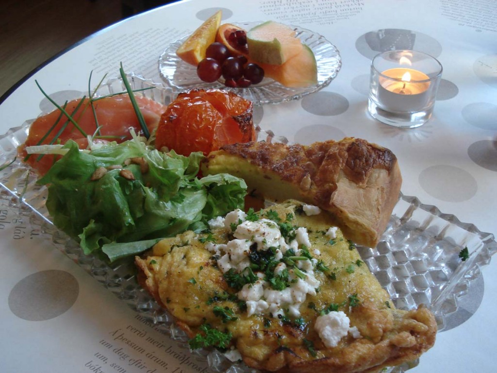 Kryddjurtabætt eggjakaka, eggjabaka (Royal), bakaður tómatur, reyktur lax, ferskt salat, nýbakað brauð og smjör, túnfisksalat, ávextir og glas af appelsínusafa.