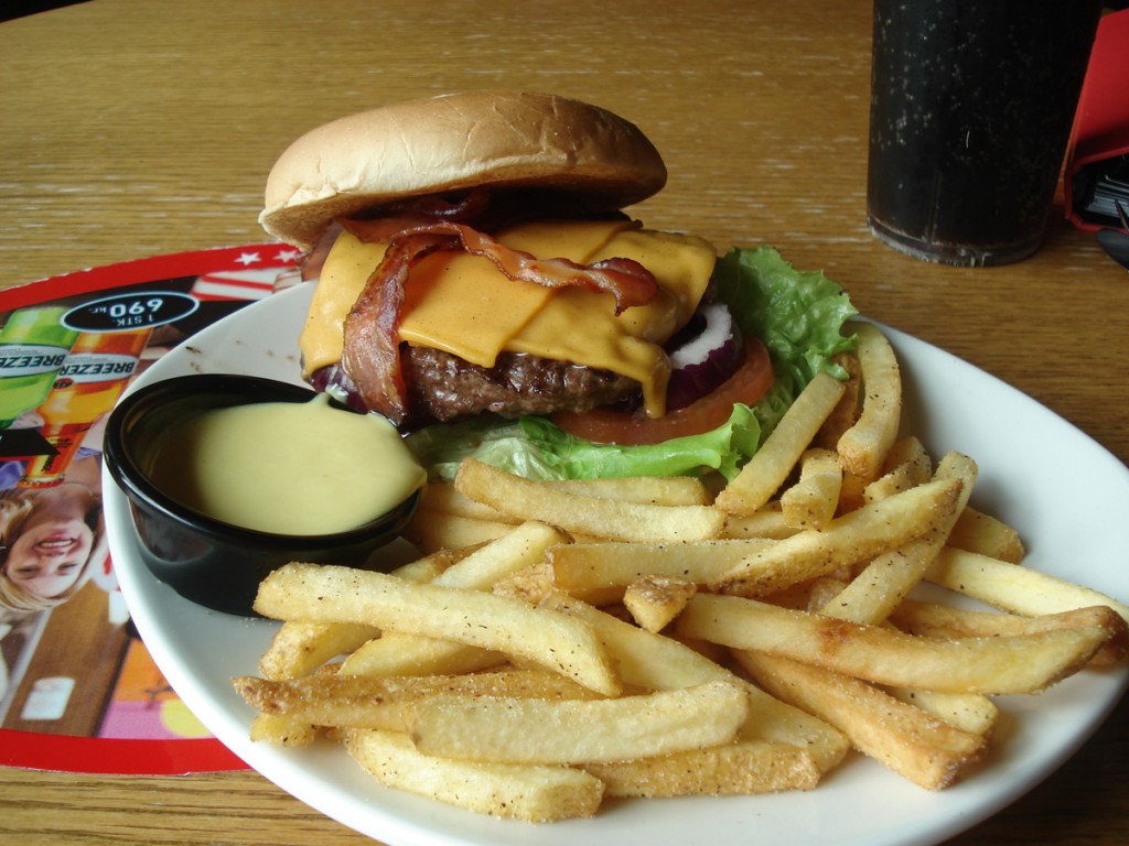 World Famous Bacon Cheeseburger Grillaður hamborgari með stökku beikoni, hjúpaður í bræddum amerískum osti. Borinn fram með hunangs-sinneps dressingu.