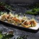 Reyktur lax á sushi teppi með wasabi snjó, eplum, stökkum shallot & rjómaosti.