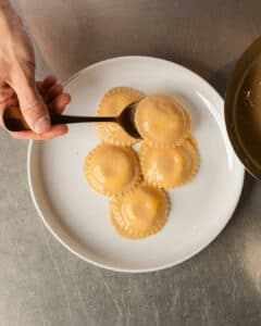 Ljúffengt Sjávarrétta Ravioli með sítrónu og Feykir osta fyllingu, borið fram með humarsósu, krækling og kolkrabba.